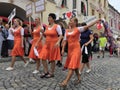 Ladies in orange, with banners and waving