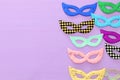 carnival party celebration concept with collection of colorful masks over purple wooden background. Top view. Flat lay.