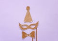 carnival party celebration concept with paper mask and clown hat over purple background. Top view. Flat lay. Royalty Free Stock Photo