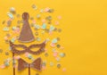 carnival party celebration concept with paper mask and clown hat over yellow background. Top view. Flat lay. Royalty Free Stock Photo