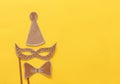 carnival party celebration concept with paper mask and clown hat over yellow background. Top view. Flat lay. Royalty Free Stock Photo