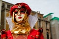 Carnival red-gold mask and costume at the traditional festival in Venice, Italy