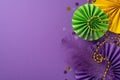 Top view of exquisite traditional beads, feather, confetti, vibrant paper fans arranged on luxurious purple background