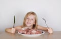 Carnivore keto diet concept - little blond girl eating raw meat