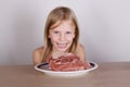 Carnivore keto diet concept - little blond girl eating raw meat Royalty Free Stock Photo