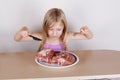 Carnivore keto diet concept - little blond girl eating raw meat