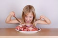 Carnivore keto diet concept - little blond girl eating raw meat