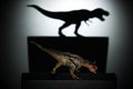 A carnotaurus casting a tyrannosaurus shadow in dark concept of strength & aspirations Royalty Free Stock Photo