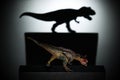 A carnotaurus casting a tyrannosaurus shadow in dark concept of strength & aspirations