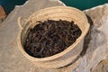 Ripe carob fruit pods in a handmade basket