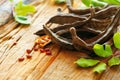 Carob. Healthy organic sweet carob pods with seeds and leaves on a wooden table. Healthy eating