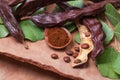 Carob. Organic carob pods with seeds and leaves on tree bark table. Healthy eating, food background