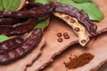 Carob. Organic carob pods with seeds and leaves on tree bark table. Healthy eating, food background