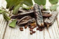 Carob on white wooden board. Healthy organic sweet carob pods Royalty Free Stock Photo