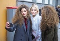 MILAN - FEBRUARY 25, 2018: Caroline Daur takes a selfie with two twins in the street before ARMANI fashion show, during Milan Fash