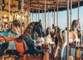 Carousel in an amusement holiday park. Merry-go-round with horses on a fairground vintage carousel