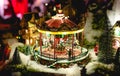 Carousel in European Christmas Fair miniature toy. Winter Christmas Eve scene with traditional miniature village houses. Vintage Royalty Free Stock Photo