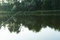 Carp fishing on beautiful blue lake with carp rods and rod pods in the summer morning. Fishing from the wooden platform Royalty Free Stock Photo