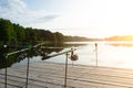 Carp fishing on beautiful blue lake with carp rods and rod pods in the summer morning. Fishing from the wooden platform Royalty Free Stock Photo