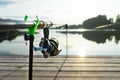 Carp fishing on beautiful blue lake with carp rods and rod pods in the summer morning. Fishing from the wooden platform Royalty Free Stock Photo