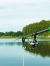 Carp fishing on beautiful blue lake with carp rods and rod pods in the summer morning. Fishing from the wooden platform Royalty Free Stock Photo