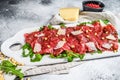 Carpaccio made of raw marbled beef. Gray background. Top view. Space for text