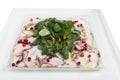 Carpaccio octopus with shpinach in a white plate Royalty Free Stock Photo