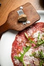 Carpaccio with parmesan, truffles and arugula on a white plate