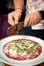 Carpaccio with parmesan, truffles and arugula on a white plate