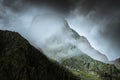 Mysterious mountain look with foggy weather and dark stormy sky.