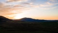 Carpathian meadow and beautiful sunset in the mountains - spring landscape, spruces on the hills, dark cloudy sky and bright