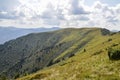 Carpathian Mountains with its peaks, hills and grassy meadows under the blue sky with clouds in summer day Royalty Free Stock Photo
