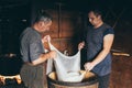 Carpathian Mountains, Ukraine - August 2020: Two men making farm cheese. Draining the whey through cheesecloth