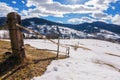 carpathian rural landscape in winter. wooden fence on the snow covered hill. village in the distant valley. bright sunny day with Royalty Free Stock Photo