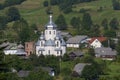 Carpathian village: catholic church, country houses, gardens and hill Royalty Free Stock Photo