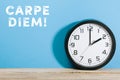 Carpe Diem words on blue colored background with clock