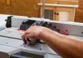 Carpenter adjusting the blade using a right angle square at the table saw Royalty Free Stock Photo