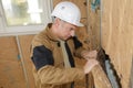 Carpenter adjusting wooden beam