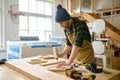 Carpenter applying glue to board wooden timbers