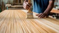 Carpenter applying natural varnish on bamboo panel in workshop Royalty Free Stock Photo