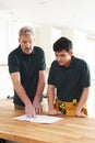 Carpenter And Apprentice Installing Luxury Fitted Kitchen Royalty Free Stock Photo