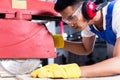 Carpenter in Asian workshop with circular saw Royalty Free Stock Photo