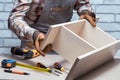 Carpenter Assembling Furniture On Desk Or Workbench.