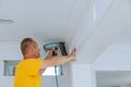 Carpenter brad using nail gun to Crown Moulding framing trim, with the warning label that all power tools Royalty Free Stock Photo