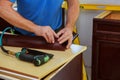 Carpenter brad using nail gun to Crown Moulding on kitchen cabinets framing trim Royalty Free Stock Photo