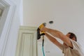 Carpenter brad using nail gun to Crown Moulding on kitchen cabinets framing trim, Royalty Free Stock Photo