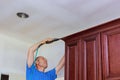 Carpenter brad using nail gun to Crown Moulding on kitchen cabinets framing trim Royalty Free Stock Photo