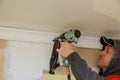 Carpenter brad using nail gun to Crown Moulding trim, warning label that all power tools Royalty Free Stock Photo