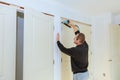 Carpenter brad using nail gun to moldings on doors,