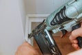 Carpenter brad using nail gun to Moulding framing trim, with the warning label that all power tools Royalty Free Stock Photo